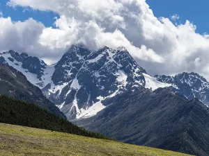 Mountain ranges with snow and meadows with yellow flowers in the highlands of eastern Tibet