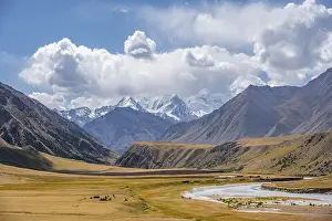 Mountain river in a valley, picturesque mountain landscape with white mountain peaks