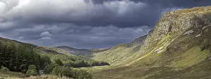 Mountain scenery showing dark rain clouds rolling in over sunny hillside and valley in Wester Ross