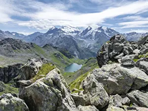 Mountain stream and mountain lake Lac de Louvie with glaciated summit of the Grand Combin