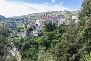 Mountain village surrounded by lush nature and historic buildings under a sunny sky