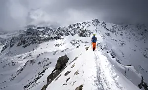 Mountaineer descending the narrow ridge of Piz Laviner