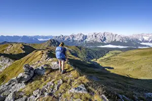 Mountaineer on a grassy ridge, mountain panorama