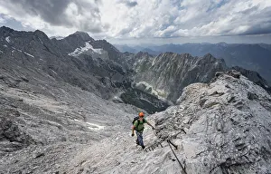 Mountaineer with helmet climbing on rock