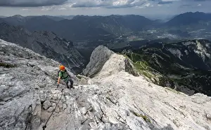 Mountaineer with helmet climbing on the rock in a secured climb
