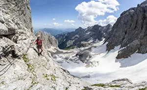 Mountaineer with helmet in a secured via ferrata
