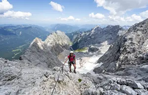 Mountaineer with helmet in a secured via ferrata