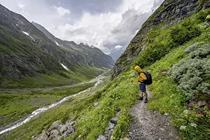 Mountaineer on a hiking trail, green mountain valley Floitengrund with mountain stream Floitenbach