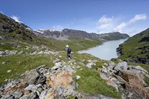 Mountaineer on hiking trail in front of Lac des Dix reservoir