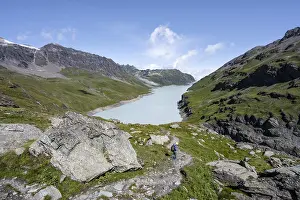 Mountaineer on hiking trail in front of Lac des Dix reservoir