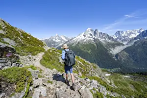 Mountaineer on a hiking trail in front of a mountain landscape