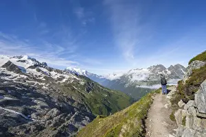 Mountaineer on a hiking trail, view into the valley with summit Mont Blanc