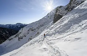 Mountaineer on hiking trail in winter with snow