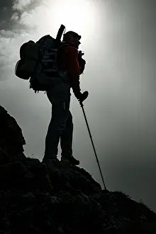 Mountaineer with luggage in the background Raetikon mountains with cloudy sky