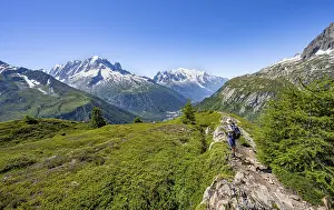 Mountaineer in front of a mountain panorama with glaciated mountain peaks
