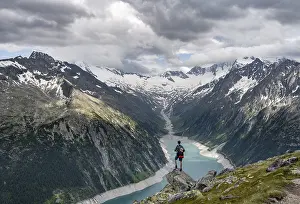 Mountaineer on a rock in front of a mountain panorama