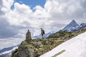 Mountaineer on a rocky hiking trail with cairns