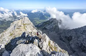 Mountaineer on a rocky narrow mountain path with mountain panorama