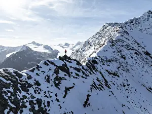 Mountaineer standing on the snow-covered Ramoljoch under a clear sky in the Alps