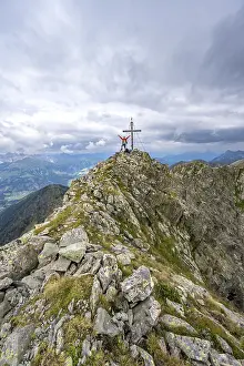 Mountaineer stretches his arms in the air