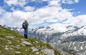 Mountaineers on a hiking trail in front of a picturesque mountain landscape