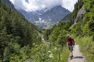 Mountaineers on a hiking trail in the Trachsellauenen Valley with the Weisse Lutschine mountain stream