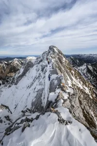 Three mountaineers on a rocky snowy ridge