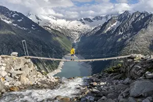 Mountaineers on a suspension bridge over a mountain stream Alelebach