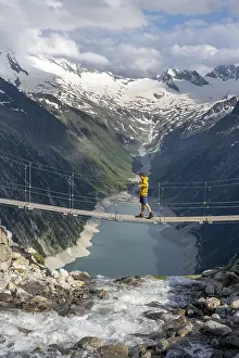 Mountaineers on a suspension bridge over a mountain stream Alelebach