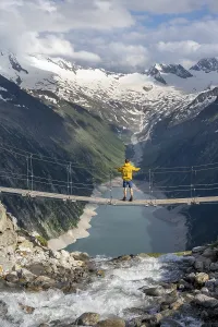 Mountaineers on a suspension bridge over a mountain stream Alelebach