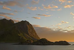 Mountains and the Norwegian Sea near Straume illuminated by warm evening light on the island of Langoya
