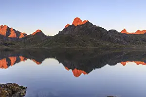 Mountains reflected in fjord, morning light