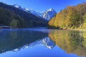Mountains reflected in lake, fog