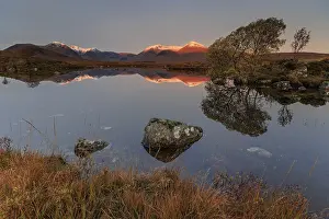 Mountains reflected in lake, morning light