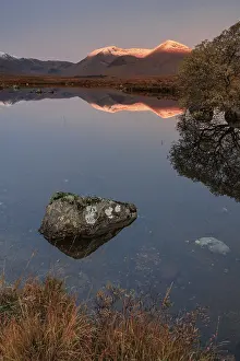 Mountains reflected in lake, morning light