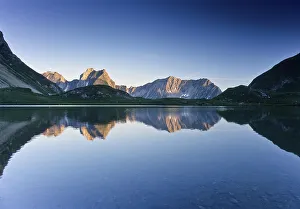 Mountains reflected in Lake Seewiessee near Memminger Huette alpine hut