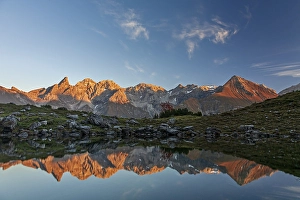 Mountains reflected in a small lake at sunset