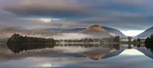 Mountains reflected in water surface with fog