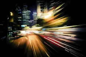 Moving through modern city street with illuminated skyscrapers