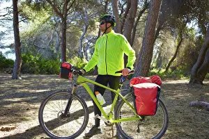 MTB Biker Bicycle touring in a pine forest with pannier racks and saddlebag