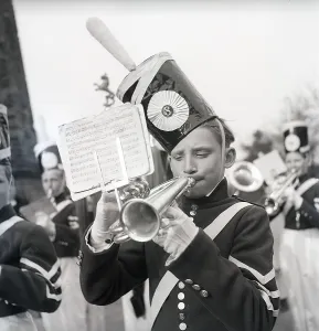 Music in the 1940s. Young boys in an orchestra is performing and playing outdoors
