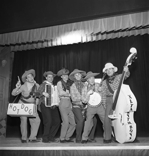 Music in the 1950s. A band on stage dressed up as cowboys playing their instruments