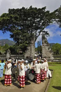 Musical band carrying two large gongs in front of the gate of Pura Ulun Danu Temple on Bratan Lake