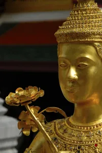 Mythic golden statue with flower at the Grand Palace in Bangkok