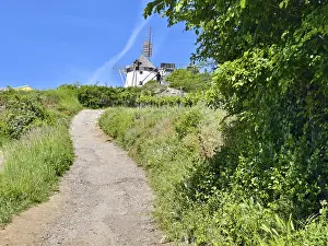 Narrow path leads through green landscape to windmill under clear sky Retz Weinviertel Lower Austria Austria
