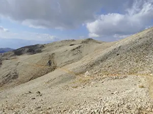 A narrow path snakes through a rocky mountain landscape