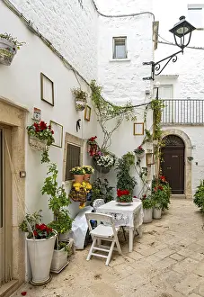 Narrow street with table and chairs in white town of Locorotondo