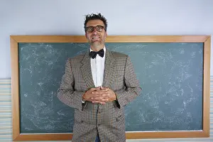 Nerd silly teacher vintage retro suit and braces on blackboard