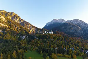 Framed Print : Neuschwanstein Castle perched on a wooded mountain in autumn light with a wide view of the valley Framed Print : Neuschwanstein Castle perched on a wooded mountain in autumn light with a wide view of the valley