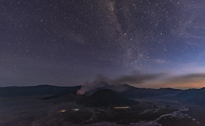 Night sky with stars, smoking volcano Mount Gunung Bromo
